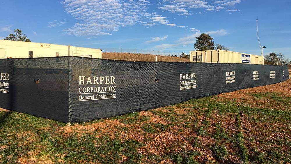 Custom-printed jobsite fence mesh screen with Harper Corporation branding